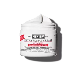 Beyaz bir arka plan uzerinde hafif kopuksu dokulu, 125 ml'lik Kiehl's Ultra Facial Cream SPF 30 kavanozu.