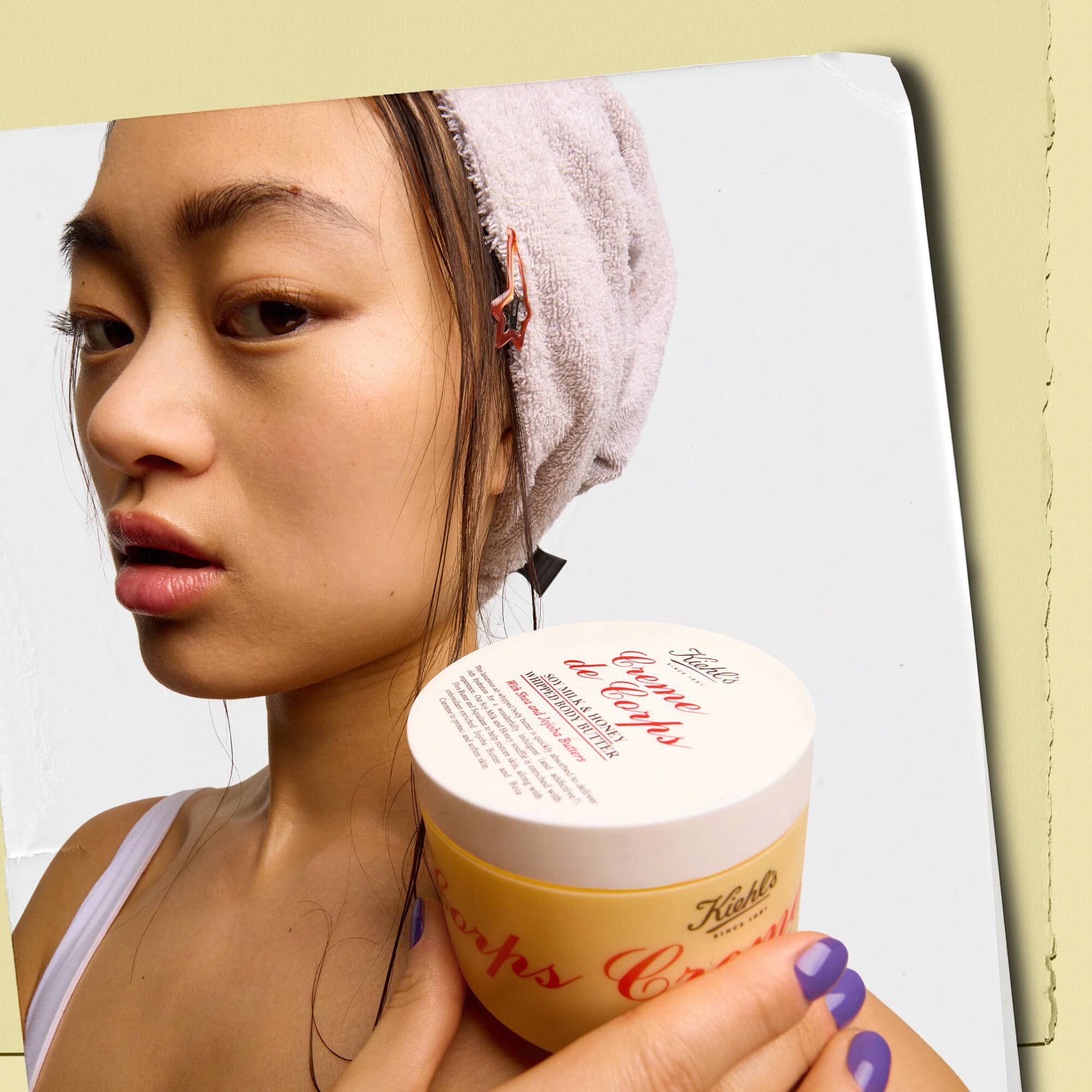 Model, Kiehl's Creme de Corps Whipped Butter Body Butter kavanozunu tutuyor.