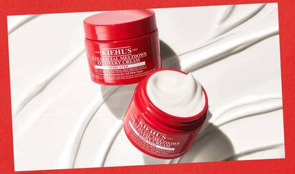 Beyaz dokulu bir fon uzerinde duzgun krem kıvrımlarıyla sergilenen, iki acık kırmızı Kiehl's Ultra Facial Meltdown Recovery Cream kavanozu, kırmızı bir cerceveyle cevrelenmiştir.