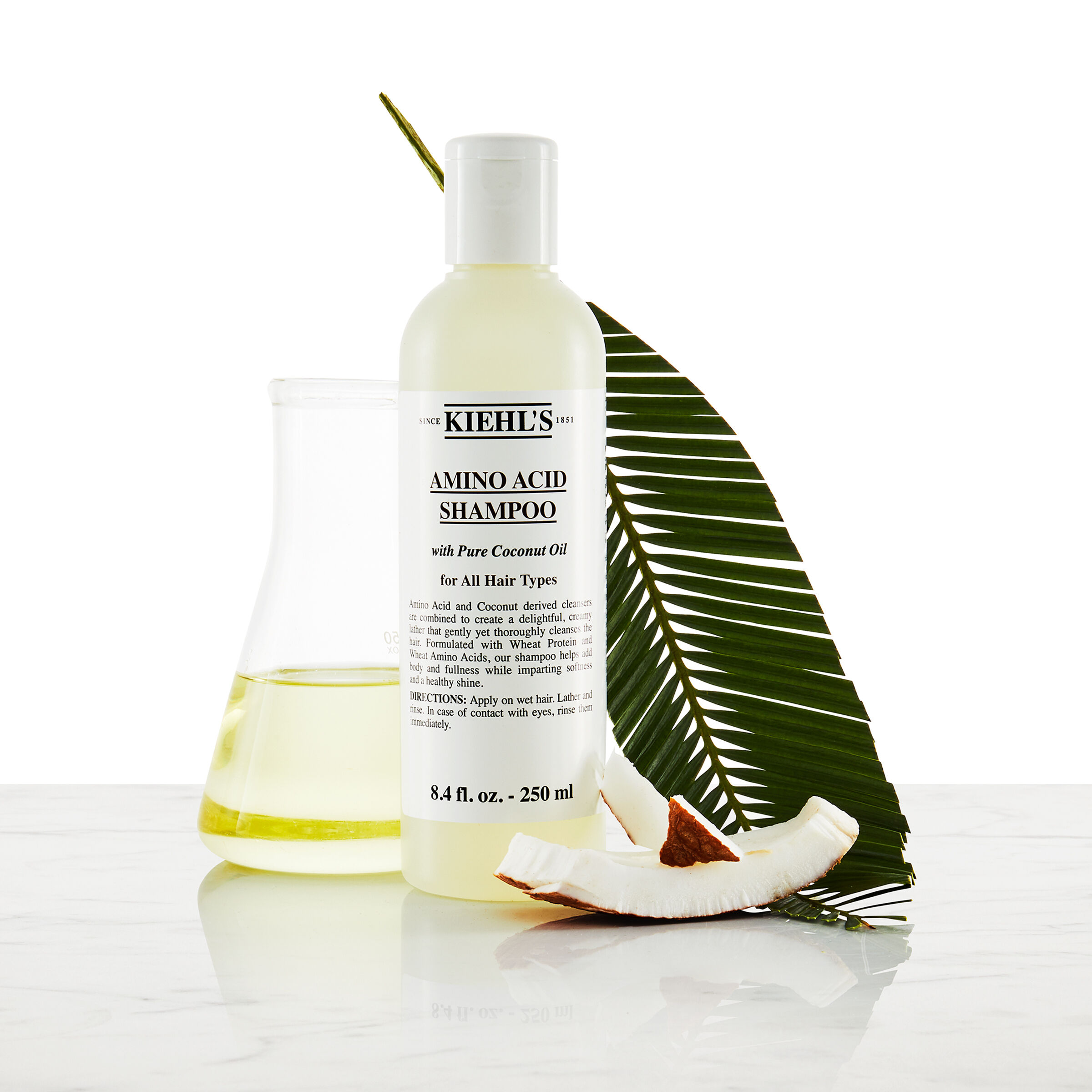 Model with a mustache and a bottle of Kiehl's Amino Acid Shampoo