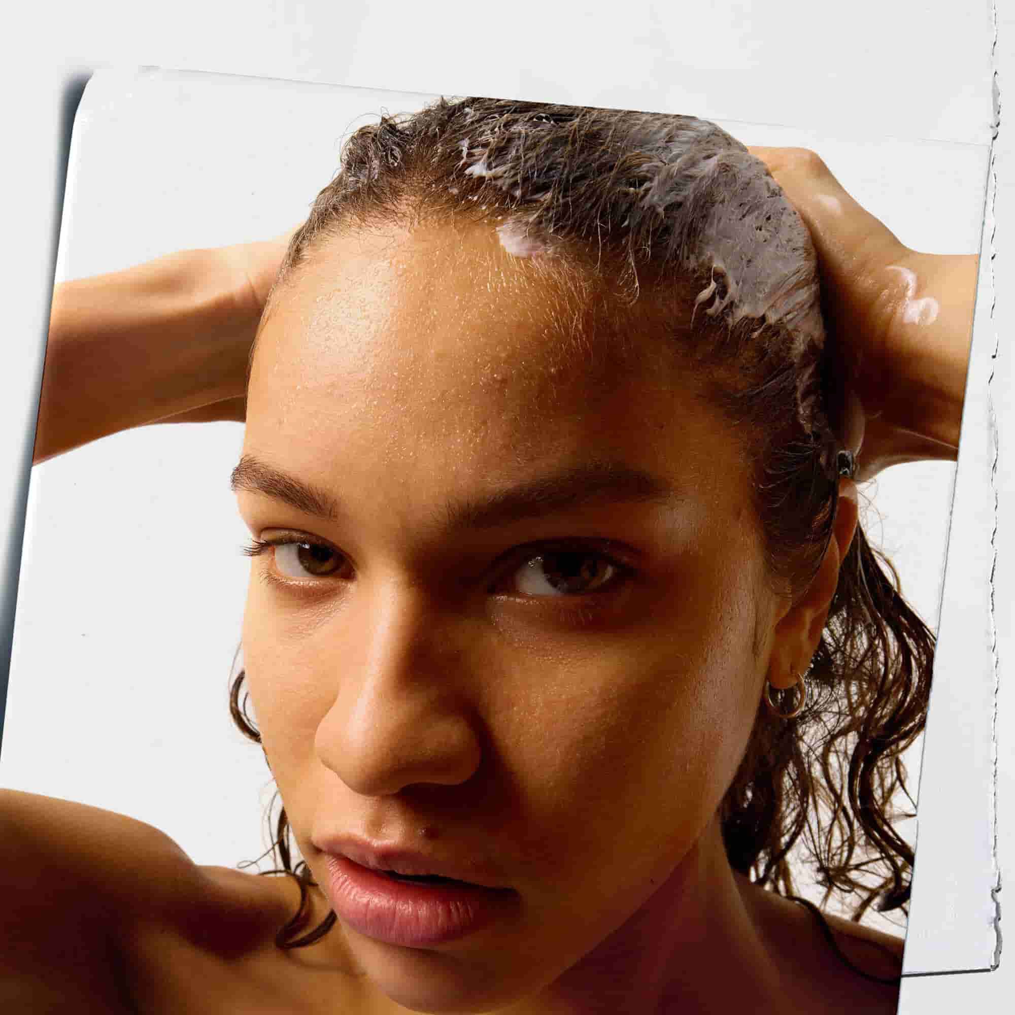 Model Using Kiehl's Amino Acid Conditioner on their hair