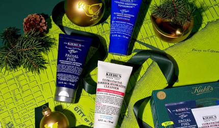 Yeşil bir zemin uzerinde harita deseniyle suslenmiş festivallere ozel grafik, uc Kiehl's urununu one cıkarıyor: "KIEHL’S FACIAL FUEL MOISTURIZER" koyu mavi bir tup, "KIEHL’S ULTRA FACIAL BARRIER-HYDRATING CLEANSER" beyaz bir tup ve "KIEHL’S CLOSE-SHAVERS SQUADRON ULTIMATE BRUSHLESS SHAVE CREAM" mavi bir tup. Duzenlemede ayrıca sarı kuş desenli altın bir Noel susu ve daha kucuk bir altın sus yer alıyor; bunlara ek olarak yeşil kurdeleler, cam dalları ve cam kozalağı bulunuyor. Altın bir kase icinde cam dalları gorulebilir ve alt sağ koşede yarım bir yeşil Kiehl's hediye kutusu gorunumu mevcut.