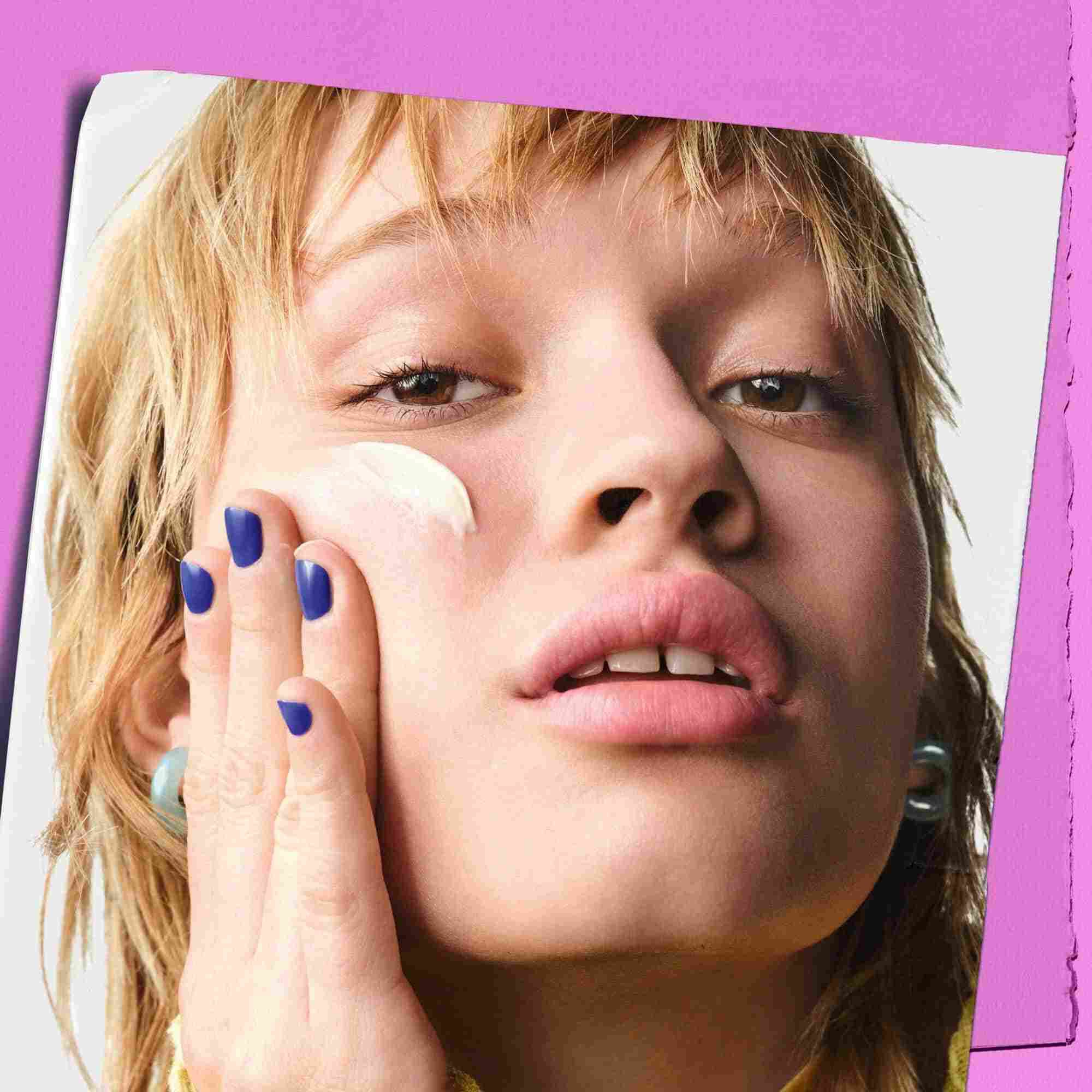 Model applying Kiehl's Super Multi-Corrective Cream to their cheek