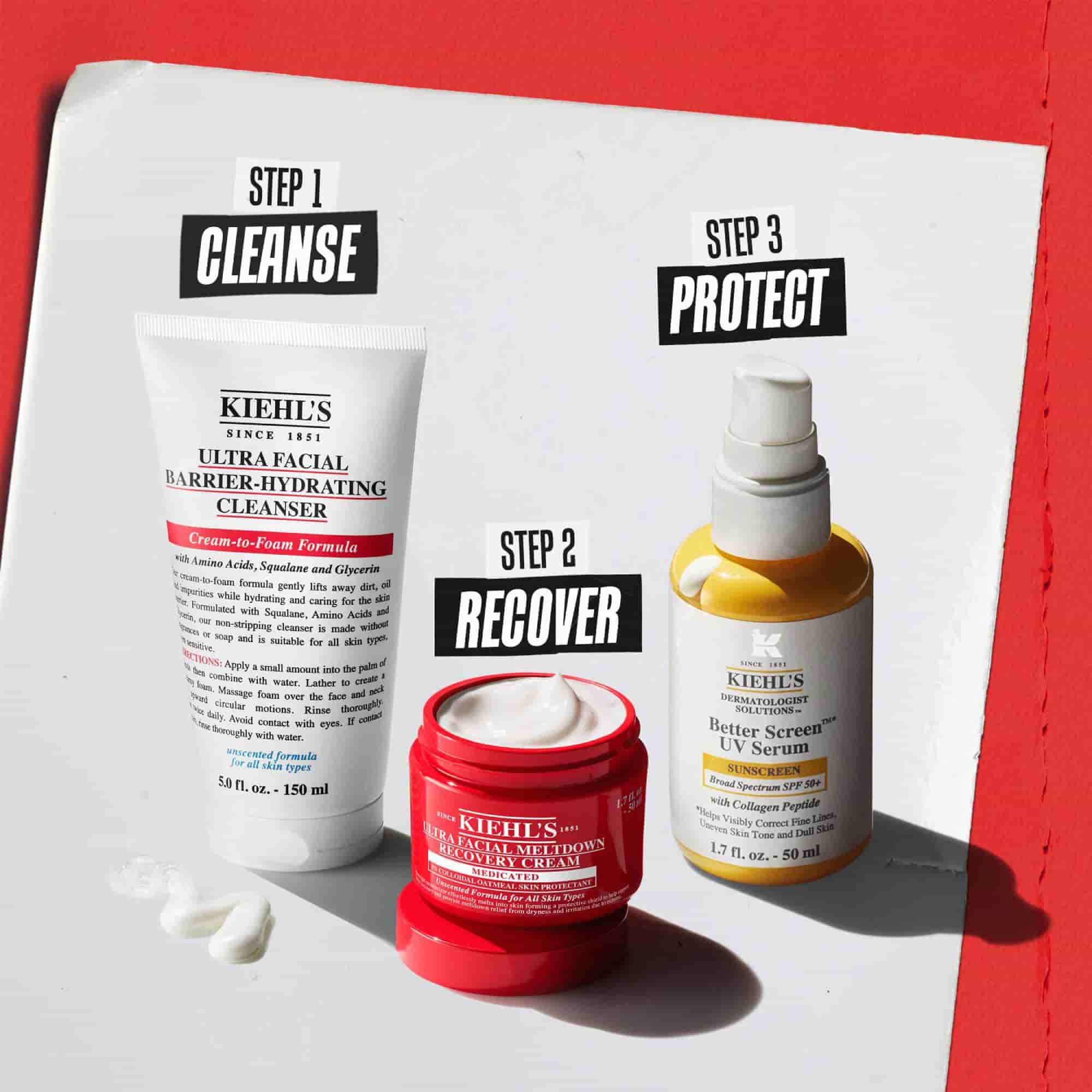 Kiehl’s cilt bakım rutini olarak etiketlenmiş uc urun: Adım 1 Temizle (Ultra Facial Barrier-Hydrating Cleanser), Adım 2 Yenile (Ultra Facial Meltdown Recovery Cream) ve Adım 3 Koru (Better Screen UV Serum) beyaz ve kırmızı bir arka plan uzerinde.