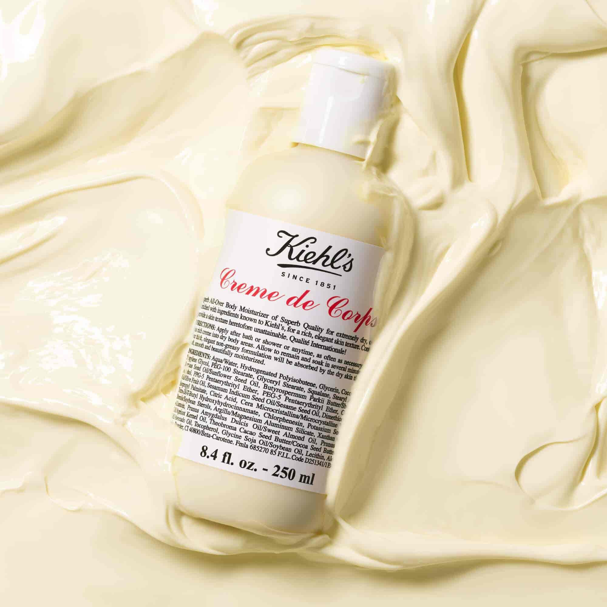 Bottle of Kiehl's Creme de Corps in a large amount of textured body lotion