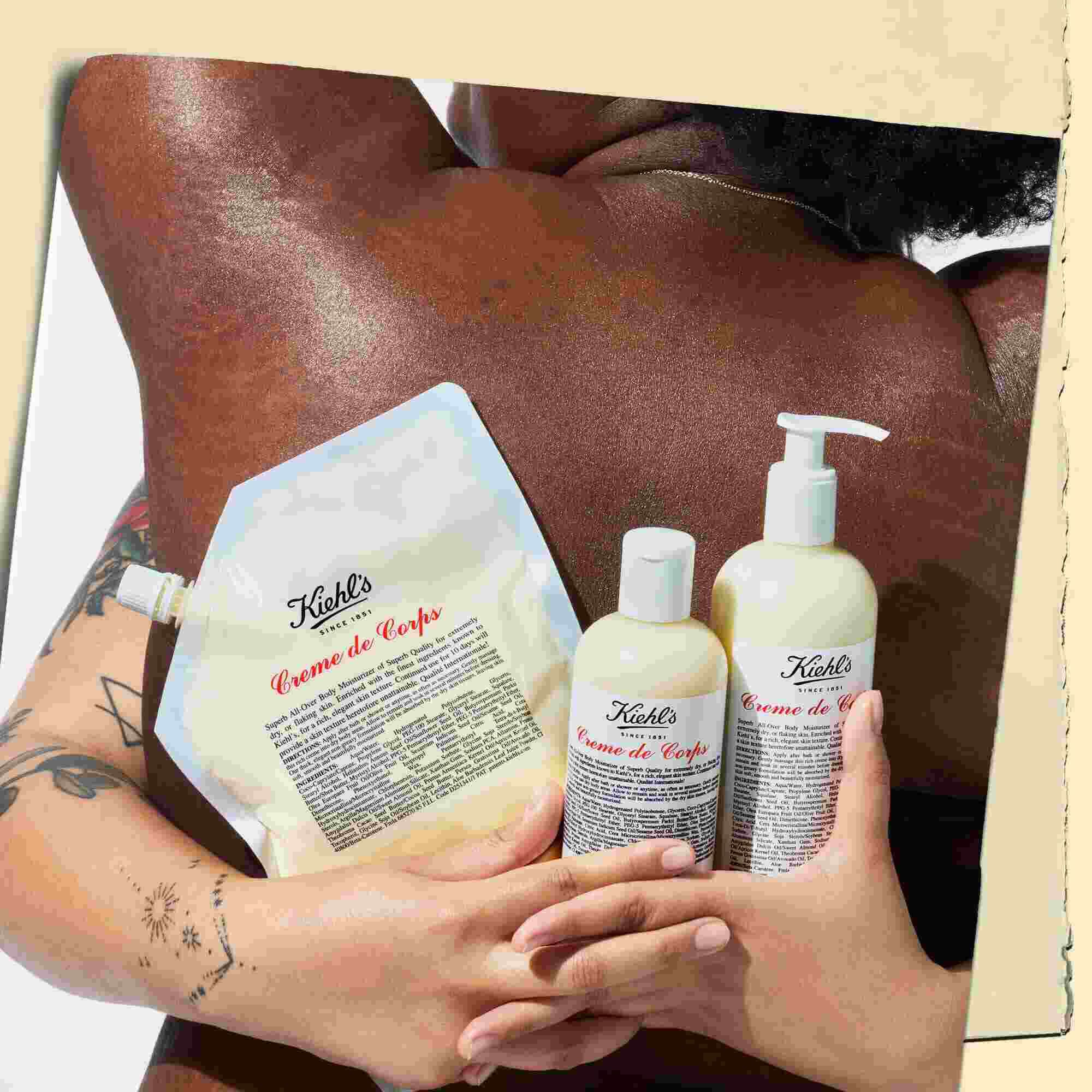 Two models embracing and holding three bottles of Creme de Corps in various sizes