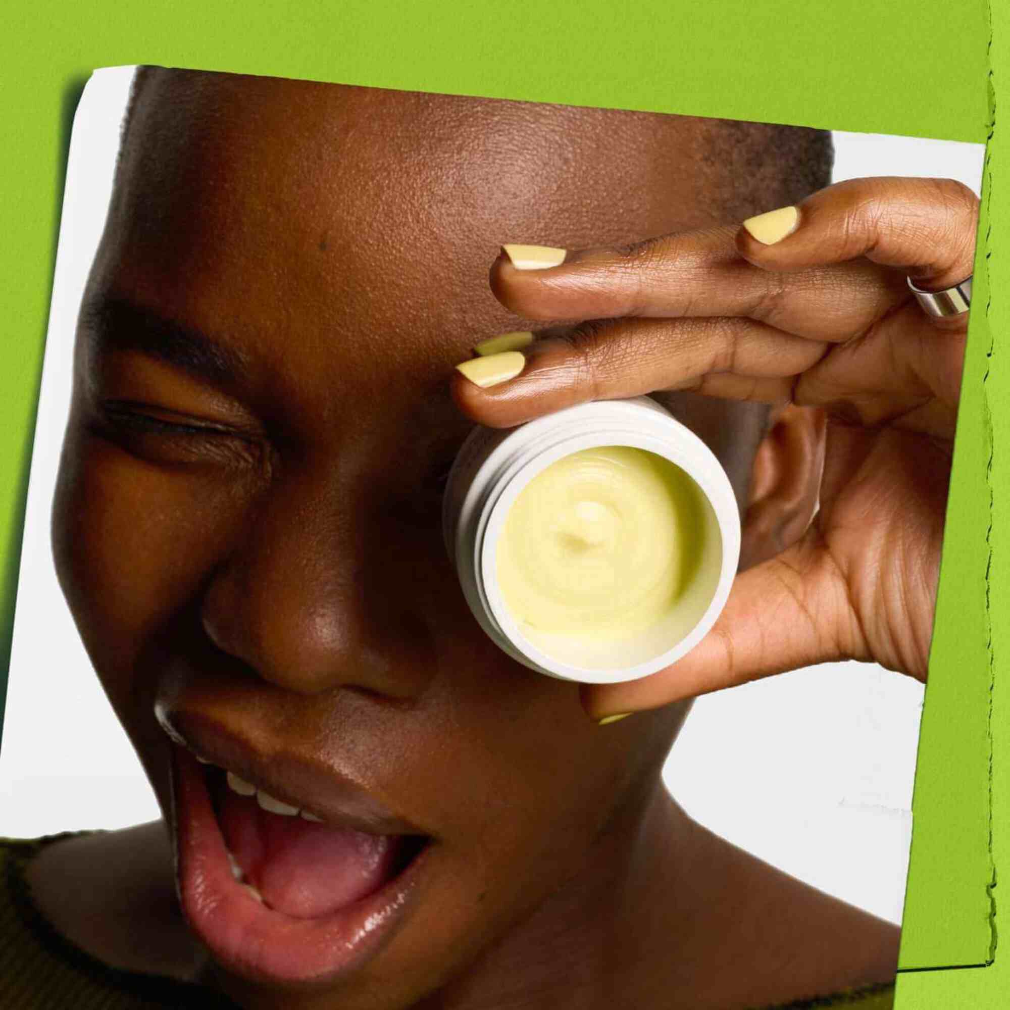 Winking model with a jar of Kiehl's Creamy Eye Treatment with Avocado covering one eye