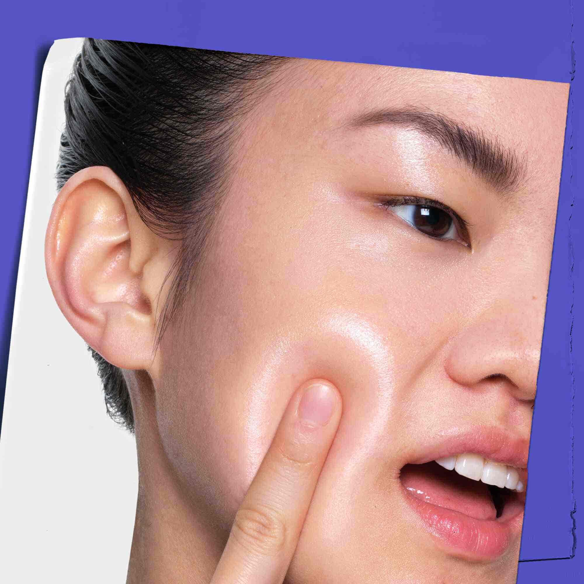 A person applying Clearly Corrective Dark Spot Solution to their skin.