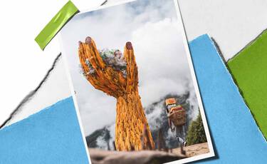 Large woven hand sculpture holding plastic waste against misty mountains, representing Kiehl’s cleanup and plastic renewal initiatives.