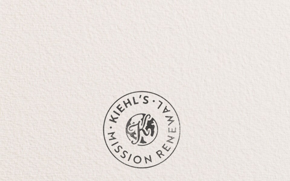 Kiehl’s Mission Renewal afişi, dairesel bir damga logosu ve "Daha dongusel bir ekonomi oluşturmak icin kusurlu yolculuğumuz" metni iceren yazıyla, markanın surdurulebilirlik ve dongusel ekonomi girişimini tanıtıyor.